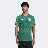Camiseta de fútbol Adidas de la selección de México, primera equipación 2026. Diseño en color verde con estampado gráfico inspirado en la cultura azteca, detalles en blanco y rojo en el cuello y las mangas, logo de la marca y escudo de la selección en el pecho.