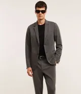 Pantalón de sastrería corte skinny, color gris claro, con trabillas en la cintura, cierre de botón y cremallera, y bolsillos laterales. Confeccionado con tecnología performance que ofrece secado rápido y resistencia a las arrugas.