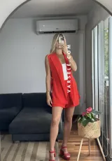 Conjunto color naranja compuesto por un chaleco sin mangas con solapas y un short de tiro alto con elástico en la parte trasera.