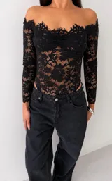 Body de encaje negro con diseño off-shoulder, mangas largas y escote con terminación en picos.