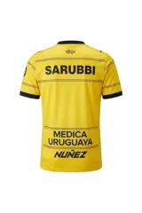 Camiseta de fútbol Puma del Club Atlético Peñarol, modelo Away Jersey Dandelion, color amarillo con finas líneas horizontales negras y detalles en negro en cuello y mangas. Incluye el logo de Puma, el escudo del club y el sponsor Antel en el frente.