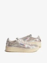 Zapatillas deportivas Autry modelo Dallas Low, color plateado metálico con textura de piel de serpiente. Tienen cordones beige y suela de goma color crema.
