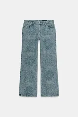 Jeans de tiro alto con corte flare y diseño de tejido jacquard con patrón floral. Presenta cinco bolsillos, trabillas en la cintura y cierre frontal con cremallera y botón.