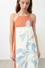 Vestido largo con estampado floral en tonos celeste y blanco, con paneles laterales color durazno. Diseño con breteles finos y corte recto.