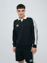 Buzo deportivo Umbro modelo Mixtape, color negro con cuello polo blanco y franjas blancas en las mangas con logo de la marca. Cuenta con puños y cintura elastizados.