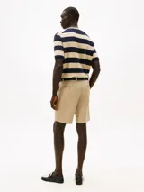 Pantalón corto beige tipo chino de Tommy Hilfiger, con bolsillos laterales y traseros, confeccionado en sarga de algodón y elastano. Incluye trabillas para cinturón.