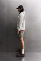 Sudadera regular fit de tejido polar con textura efecto pelo, color gris claro. Cuenta con cuello subido, capucha ajustada, manga larga ranglán, bolsillos laterales en la cadera y bajo asimétrico más largo en la espalda. Los acabados son con cinta elástica.