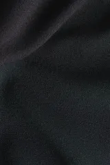 Pantalón tobillero de maternidad en punto interlock pesado color negro, de tiro alto con elástico oculto, pinzas en la parte trasera y piernas ajustadas con bajo acampanado.