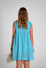 Vestido corto celeste con perforaciones, escote en V y mangas cortas con volados.