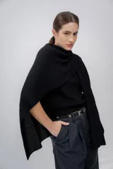 Ruana negra de tejido de punto grueso, confeccionada en 100% baby alpaca.