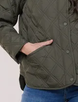 Campera matelaseada color verde militar con diseño capitoneado de rombos, escote redondo sin cuello y cierre frontal con broches a presión. Cuenta con bolsillos frontales oblicuos y ruedo curvo con aberturas laterales.