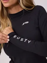 Remera técnica de natación manga larga con protección UV, cuerpo negro liso y mangas con estampado botánico multicolor. Presenta cuello redondo y logo de la marca estampado en el pecho.