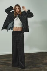 Blazer de corte recto con estampado de cuadros, cuello solapa y manga larga con hombreras. Presenta cierre frontal con botones ocultos bajo solapa y bolsillos delanteros con solapa.