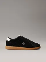 Zapatillas Calvin Klein de perfil bajo elaboradas en ante negro, con suela cupsole de goma marrón. Presentan detalles en contraste de color blanco en el talón y la lengüeta, además del monograma 'ck' bordado en el lateral.