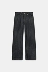 Jeans de tiro bajo y corte recto, confeccionados en denim negro con estampado de rayas verticales finas. Presentan cinco bolsillos, trabillas para cinturón y cierre frontal con cremallera y botón metálico.