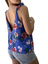 Blusa azul con estampado de flores rojas, blancas y amarillas, con breteles finos que se atan en los hombros.