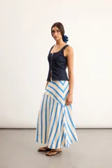 Pollera larga de algodón tejido, color beige con rayas diagonales azules, silueta en línea A y corte asimétrico.