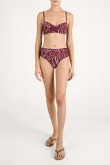 Top de bikini estructurado tipo corsetero, con aro, tirantes finos con tachas metálicas y diseño con estampado animal print en tonos bordó y rosado.