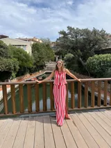 Falda larga tejida a rayas verticales rojas y blancas, con pretina elástica y tajos laterales.