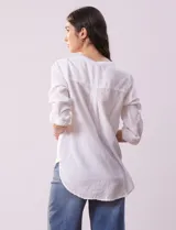 Blusa color beige de lino, marca Dash. Cuello a la base, escote en V y abertura con botones. Delantera con bolsillos. Largo de manga regulable con presilla y botón.