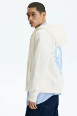 Campera con capucha H&M de felpa boxy en color beige, con cierre frontal, bolsillos tipo canguro y pequeño estampado azul en el pecho con la frase 'Not for Ceremony'.