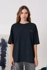 Remera de silueta amplia con hombros caídos y manga corta extendida. Confeccionada en algodón de peso medio con cuello redondo y estampa frontal pequeña.