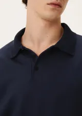 Polera azul marino de manga larga con cuello polo y tapeta de dos botones.