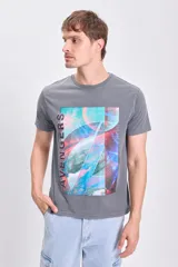 Camiseta gris de manga corta con estampado de los Avengers. El modelo usa talle L.