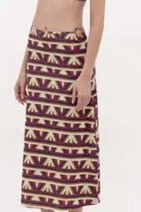 Falda larga de licra con diseño estampado geométrico multicolor, drapeado asimétrico y detalle de argolla en la cintura.