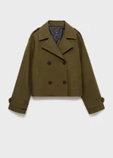 Chaqueta corta de doble botonadura en color verde militar, con cuello de solapa, bolsillos laterales, trabillas en los hombros y mangas largas con puños abotonados.