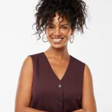 Chaleco de traje color púrpura, con escote en V, cierre frontal con botones y corte entallado.