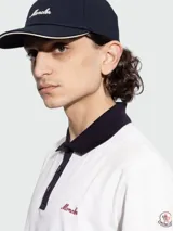 Gorra de baseball Moncler color azul marino, con visera curva y detalle de borde en color crema. Presenta el logo de la marca bordado en la parte frontal en color crema.