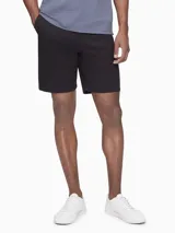 Short negro de corte chino, con bolsillos laterales y traseros, cierre con cremallera y botón, trabillas para cinturón y logo bordado.