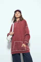 Buzo con capucha de calce relajado, confeccionado en tela con efecto lavado desgastado. Presenta costuras a la vista en color contrastante y un bolsillo frontal tipo canguro.