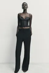 Top estilo corset con copas de tejido satinado y cuerpo de encaje semitransparente con varillas. Presenta tirantes finos ajustables y cierre lateral con cremallera oculta.