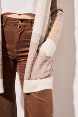 Cárdigan largo de punto con diseño color block en tonos beige, marrón y blanco. Tiene bolsillos delanteros y corte holgado.