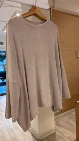 Buzo beige de lanilla, de corte holgado y mangas largas.