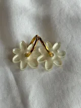 Aros de argolla metálica con dije colgante en forma de flor de acrílico color rosado.