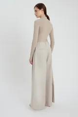 Pantalón de corte ancho (relaxed fit) color gris claro, con pinzas frontales y efecto lavado sedoso.