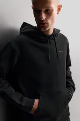 Sudadera de hombre Zara Athleticz de ajuste relajado (relaxed fit), color marrón, confeccionada en tejido técnico compacto con mezcla de algodón y elasticidad. Cuenta con cuello con capucha ajustable con cordones negros, manga larga, bolsillo frontal tipo canguro con un pequeño bolsillo termofijado con cierre, y acabados con rib en puños y cintura.