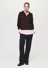 Sweater de punto grueso marrón oscuro, de corte recto, con cuello de solapa ancha, cierre frontal de cremallera y manga larga.