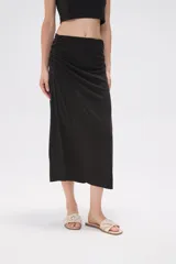 Falda midi de corte tubo confeccionada en modal, con detalle de frunces laterales que aportan movimiento y textura a la prenda.