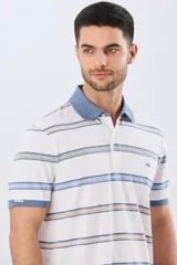 Remera polo de manga corta con diseño a rayas horizontales en tonos azules, celestes, verdes y beiges sobre base azul marino. Presenta cuello camisero con cierre frontal de botones y un pequeño logo bordado en el pecho.