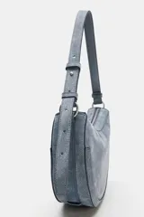 Bolso bandolera de piel color gris con diseño ovalado tipo media luna. Cuenta con cierre de cremallera, asa corta de hombro ajustable y detalles metálicos.
