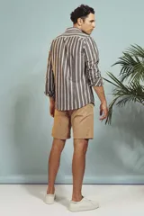 Camisa de manga larga en color salmón con estampado de pequeños motivos geométricos oscuros, cuello clásico y cierre frontal con botones.