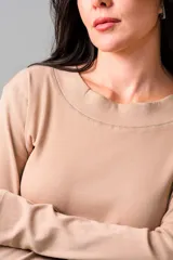 Remera de manga larga en tejido de punto acanalado color beige, con cuello redondo y diseño ajustado al cuerpo.