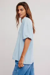 Remera de algodón celeste, de corte oversize con escote en V amplio y mangas cortas caídas.