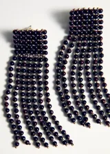 Aros colgantes largos confeccionados con cuentas de cristal borgoña y pequeñas cuentas doradas, con base rectangular y flecos de cuentas colgantes.