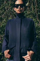 Chaqueta de estilo utilitario confeccionada en algodón con efecto lavado. Presenta cuello solapa, cierre frontal con botones ocultos bajo solapa, manga larga y bolsillos delanteros con solapa.