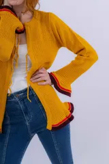 Saco de lana merino color mostaza, tejido a punto con detalle de volados en ruedo y puños. Tiene dos cierres frontales hechos en crochet a mano.